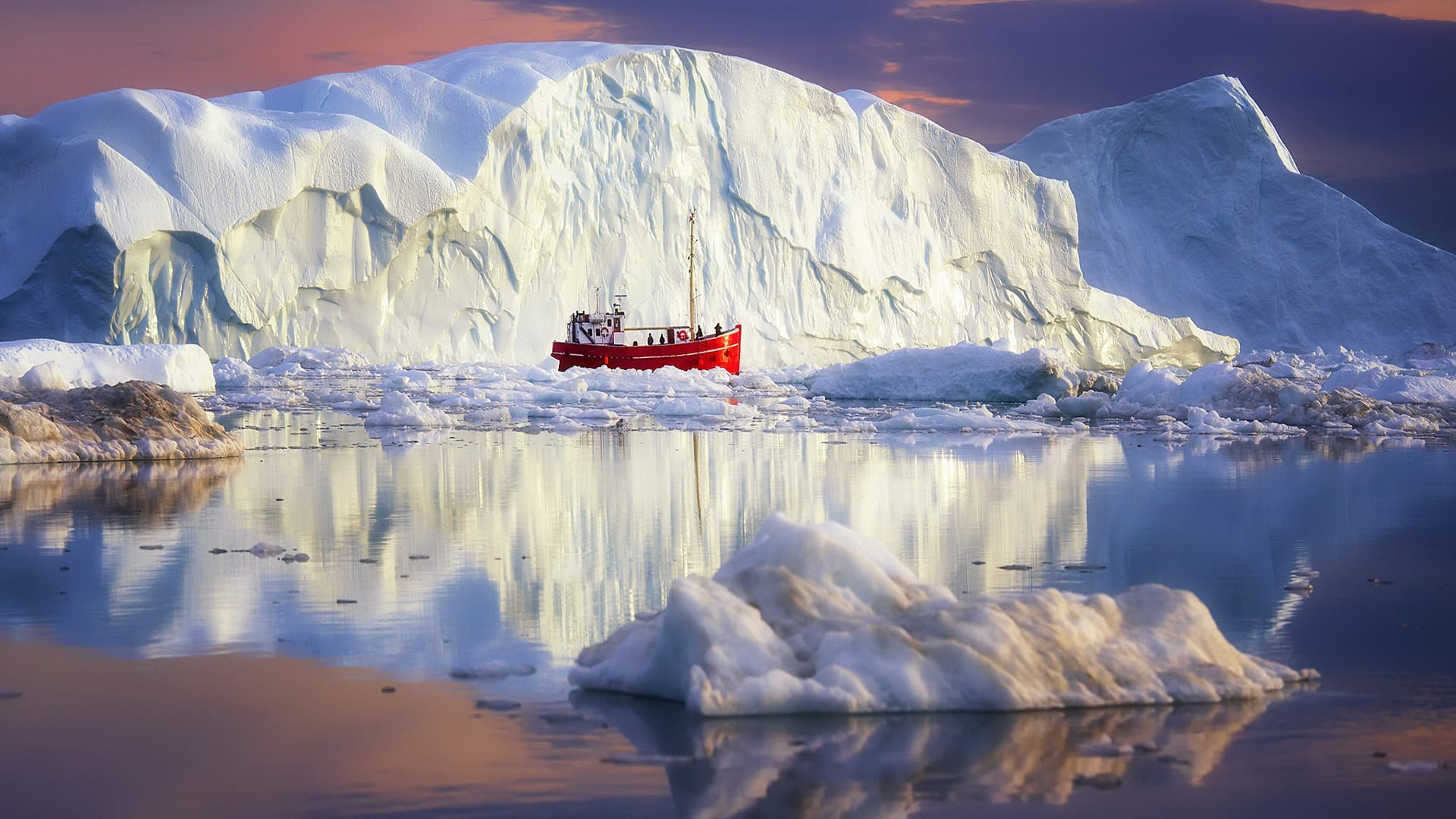 a boat near an iceber in the Disko Bay, Greenland.